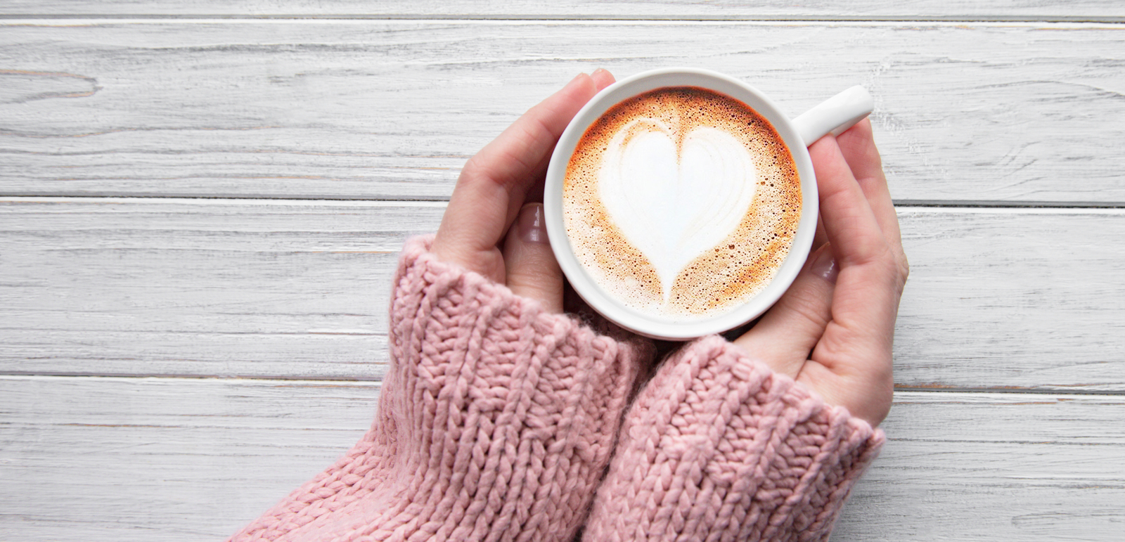 hands around coffee cup with heart