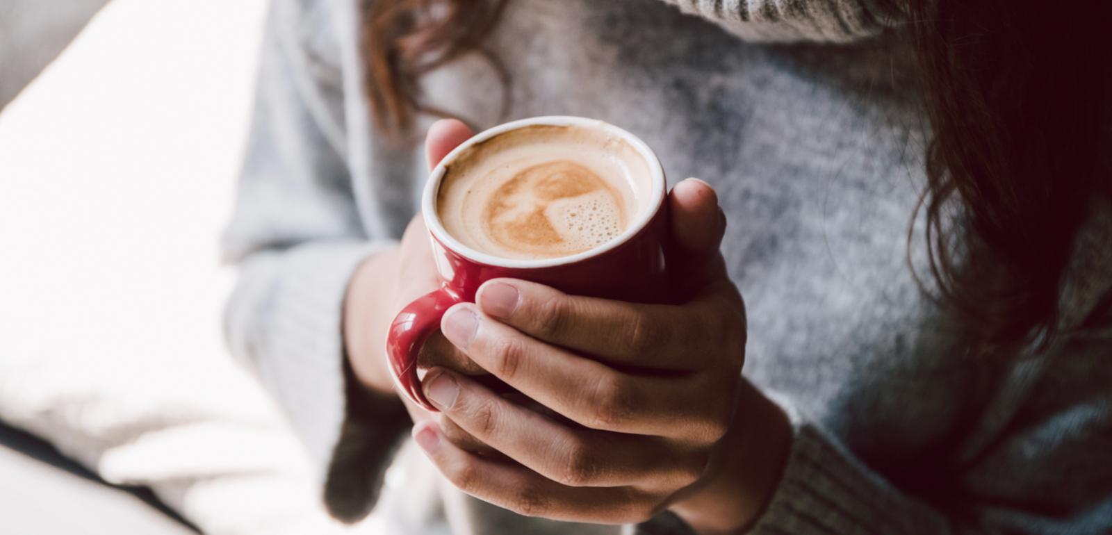 woman waking up and holding coffee cup