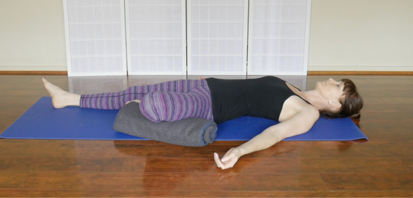 woman demonstrating restorative yoga version of fish pose